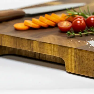 End-grain snijplank van acaciahout met handgreep. Warme houtnerf, ambachtelijke afwerking, subtiele zijgravure – gefotografeerd in Meesterbrander-stijl.