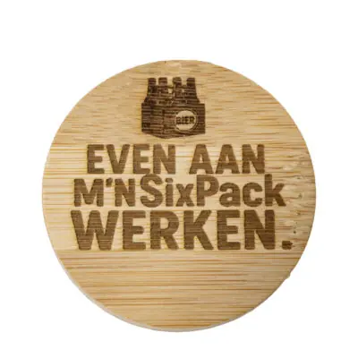 Ronde houten bieropener met gegraveerde tekst “Even aan mijn sixpack werken”, gemaakt van bamboe met metalen onderzijde. Ambachtelijk gegraveerd door De Meesterbrander.