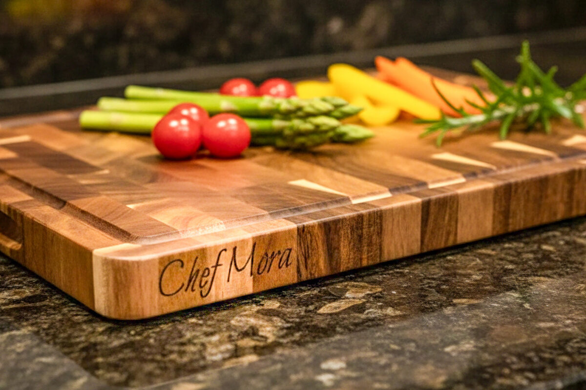 End-grain snijplank met handgreep en vochtgroef. Warme houtnerf, ambachtelijke afwerking, subtiele zijgravure – gefotografeerd in Meesterbrander-stijl.