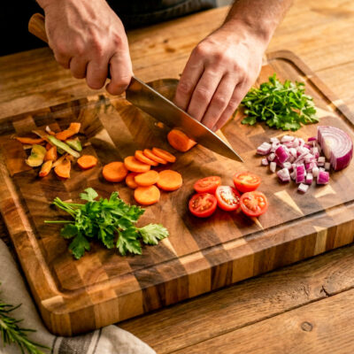 Luxe end-grain snijplank van acaciahout in De Brandmeester-stijl. Ambachtelijk handgemaakt, duurzaam, met subtiele zijgravure en verzonken handgreep en sapgroef End-grain snijplank met handgreep en vochtgroef. Warme houtnerf, ambachtelijke afwerking, subtiele zijgravure – gefotografeerd in Meesterbrander-stijl.