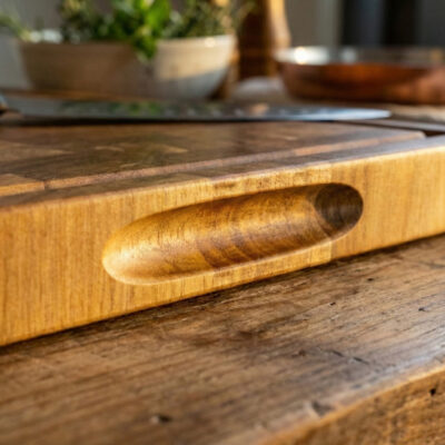 Luxe end-grain snijplank van acaciahout in De Brandmeester-stijl. Ambachtelijk handgemaakt, duurzaam, met subtiele zijgravure en verzonken handgreep en sapgroef End-grain snijplank met handgreep en vochtgroef. Warme houtnerf, ambachtelijke afwerking, subtiele zijgravure – gefotografeerd in Meesterbrander-stijl.