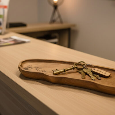 Houten schaaltje met gegraveerde B&B-naam op luxe wastafel in hotel- of B&B-badkamer