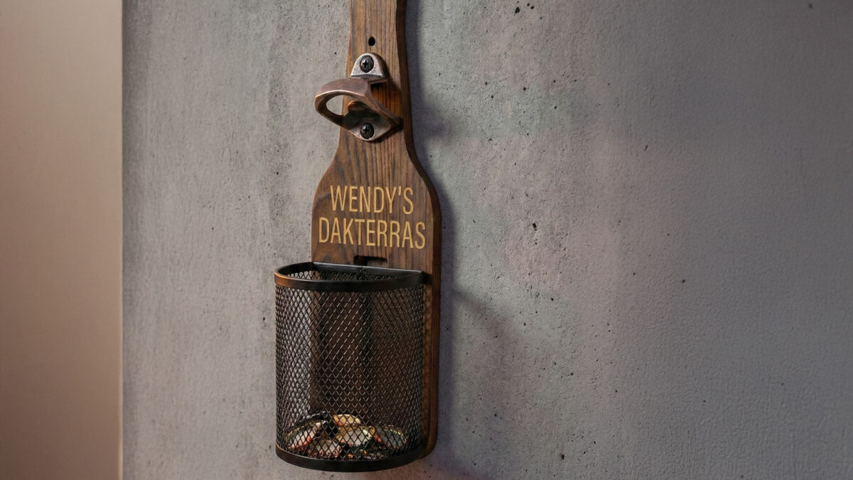 Afneembaar metalen dopjesmandje gevuld met bierdopjes bij houten wandbieropener