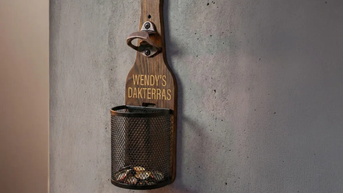 Houten Wandbieropener met Dopjesmandje Afneembaar metalen dopjesmandje gevuld met bierdopjes bij houten wandbieropener