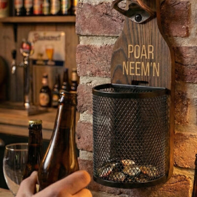 Afneembaar metalen dopjesmandje gevuld met bierdopjes bij houten wandbieropener