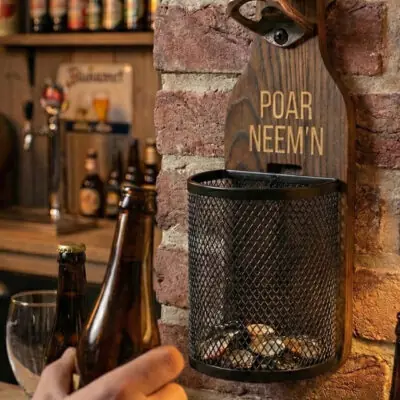 Houten Wandbieropener met Dopjesmandje Afneembaar metalen dopjesmandje gevuld met bierdopjes bij houten wandbieropener