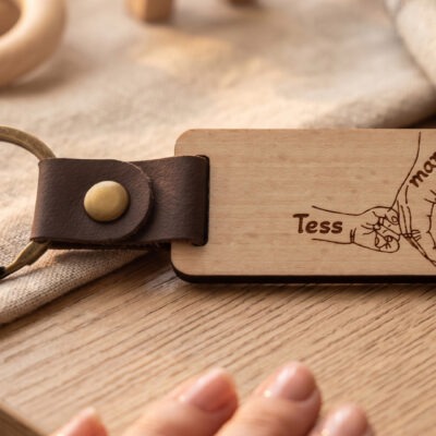 Houten sleutelhanger voor moederdag met moederhand en kinderhandjes met namen gegraveerd