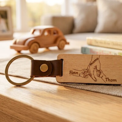 Houten sleutelhanger voor moederdag met moederhand en kinderhandjes met namen gegraveerd