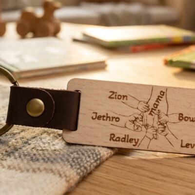 Houten sleutelhanger voor moederdag met moederhand en kinderhandjes met namen gegraveerd