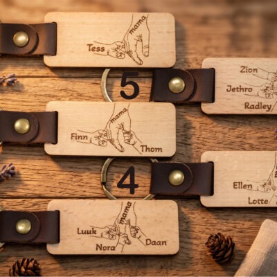 Houten sleutelhanger voor moederdag met moederhand en kinderhandjes met namen gegraveerd